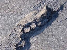 Um dos muitos buracos do pavimento da ponte sobre o Coura